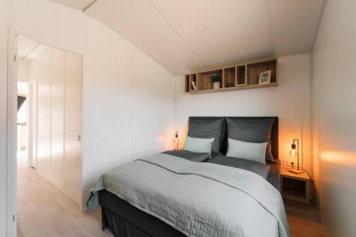ein Schlafzimmer mit einem Bett und einer weißen Wand in der Unterkunft gemütliches voll ausgestattes Tiny House in Vilseck
