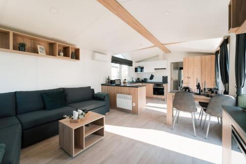 a living room with a blue couch and a kitchen at gemütliches voll ausgestattes Tiny House in Vilseck