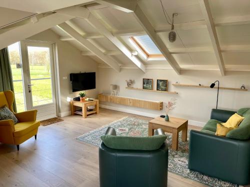a living room with two couches and a tv at Vakantiehuis Noflik Nijemirdum in Nijemirdum