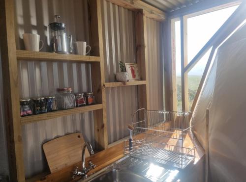 a kitchen counter with a sink and a window at Pom Gratz - EcoDomes in Hartebeest Rivier