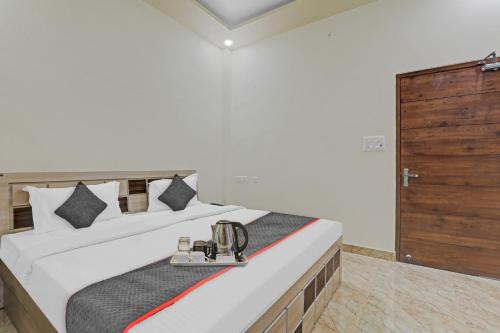 a bedroom with a large bed with a wooden cabinet at Townhouse 1160 P.s.Palace Near Amausi Metro Station in Lucknow