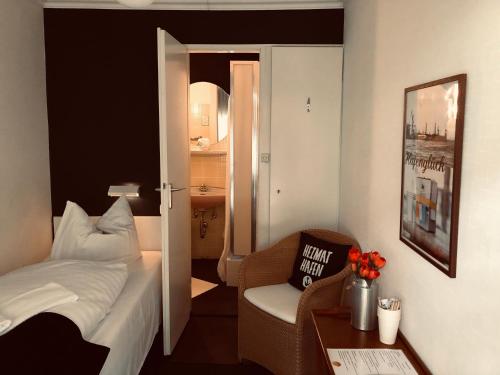 ein Hotelzimmer mit einem Bett, einem Stuhl und einem Tisch in der Unterkunft City Hostel by beans parc in Wilhelmshaven