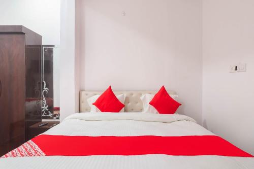 een slaapkamer met een rood en wit bed met rode kussens bij SPOT ON Royal Inn in Charbagh