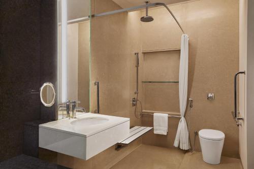 a bathroom with a white sink and a toilet at The Westin Hyderabad Mindspace in Hyderabad