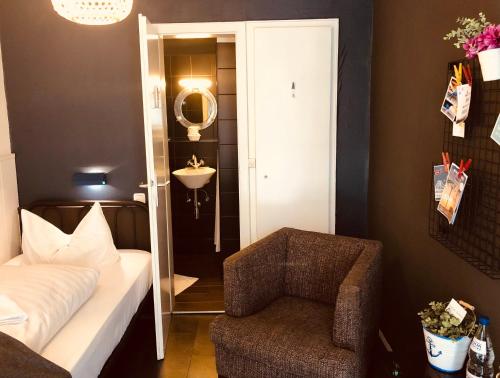 a bedroom with a bed and a chair and a mirror at City Hostel by beans parc in Wilhelmshaven