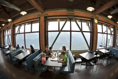 a group of people sitting at tables in a restaurant at Alyeska Resort in Girdwood
