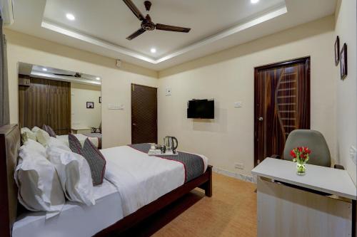 Schlafzimmer mit einem Bett, einem Schreibtisch und einem TV in der Unterkunft OYO Townhouse 1090 G SILVER HOTELS NEAR US BIOMETRIC in Chennai
