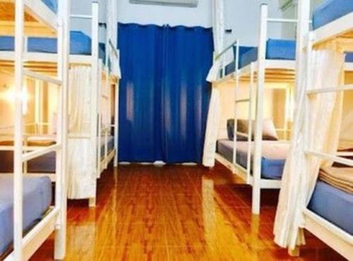 Zimmer mit 3 Etagenbetten und blauen Vorhängen in der Unterkunft PrivateDorm#Aircon#Freewifi#Sharedbath#Cozy#@Oldcity in Chiang Mai