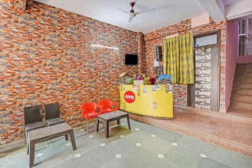 een bakstenen muur met 2 stoelen en een tafel in een kamer bij Flagship Second Home Guest House Near Omaxe Celebration Mall in Gurgaon