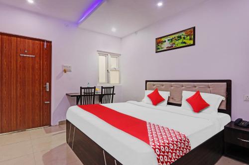 a bedroom with a large bed with red and white pillows at Collection O Hotel Prime A-One Inn Near Chaudhary Charan Singh International Airport in Bijnaur