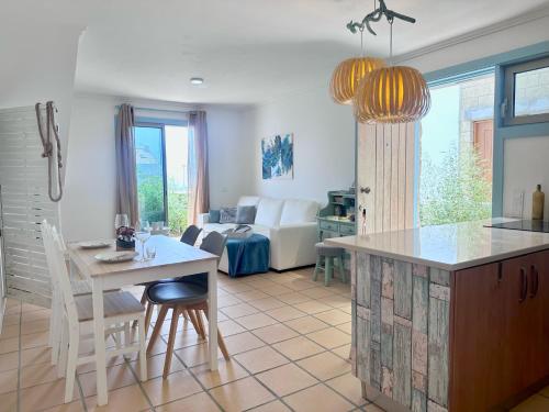 a kitchen and living room with a table and a couch at Casa bamboo in Porto Santo