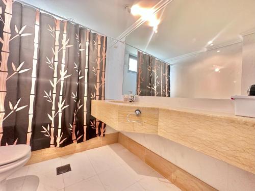 a bathroom with a toilet and a shower curtain at Casa bamboo in Porto Santo