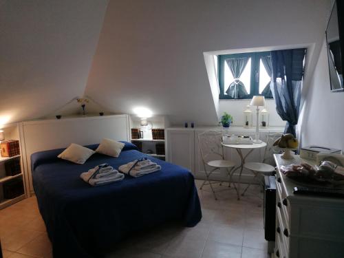 Un dormitorio con una cama con sábanas azules y una mesa. en Coros, en Nuoro
