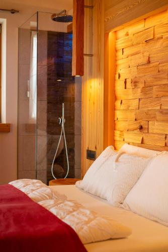 a bedroom with a bed and a glass shower at Casera Degnona in Chies dʼAlpago