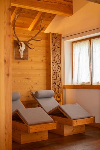 a room with two meditation benches in a log cabin at Casera Degnona in Chies dʼAlpago