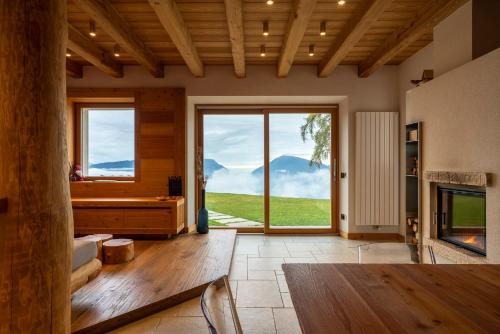 a living room with a large window with a mountain view at Casera Degnona in Chies dʼAlpago