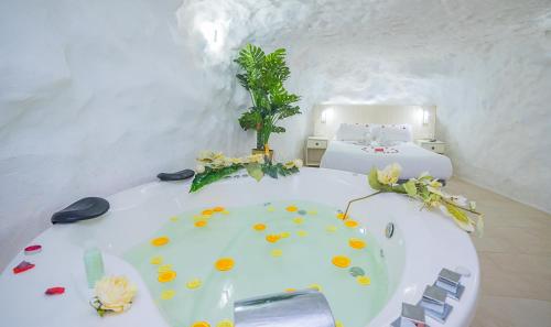a white room with a bed and a bath tub at Casa Rural Las Colmenas in Alcalá del Júcar