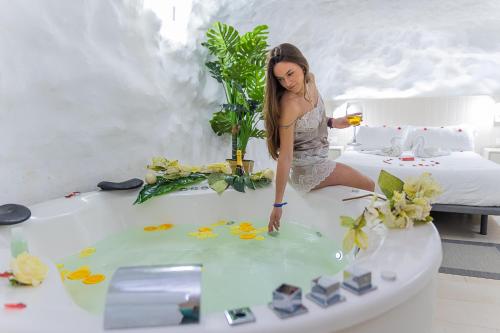 a woman sitting in a bath tub with a glass of wine at Casa Rural Las Colmenas in Alcalá del Júcar
