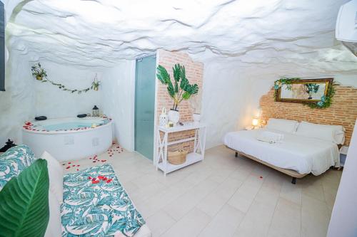 a bedroom with a bed and a tub in a room at Casa Rural Las Colmenas in Alcalá del Júcar