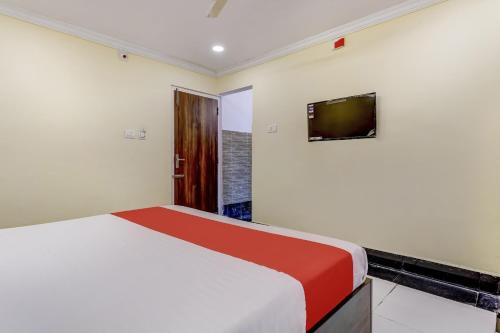 a bedroom with a bed and a tv on the wall at Collection O Hotel Srinivasa Residency in Tirupati