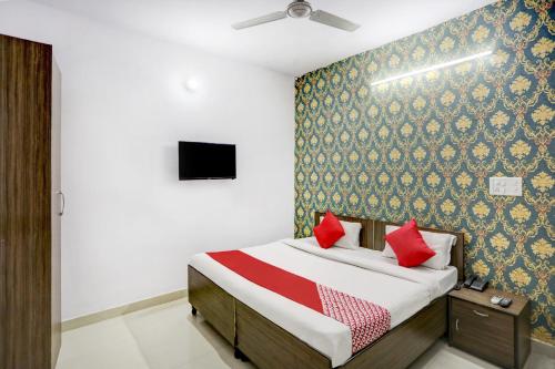 a bedroom with a bed with red pillows at Super Hotel O Blissbourn in New Delhi