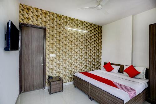 a bedroom with a bed with red pillows at Super Hotel O Blissbourn in New Delhi