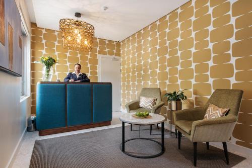 a man standing at a podium in a lobby at Zest Boutique Hotel by The Living Journey Collection in Cape Town