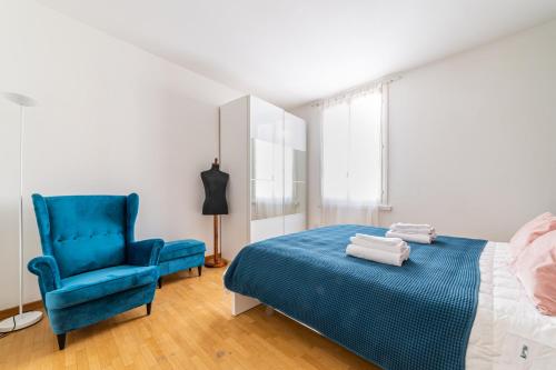 a bedroom with a blue bed and a blue chair at Officina7 Large in Parma