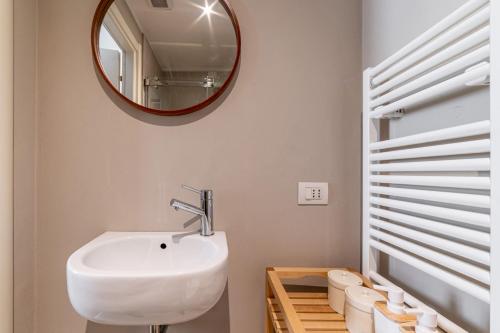uma casa de banho com um lavatório branco e um espelho. em Officina7 Large em Parma
