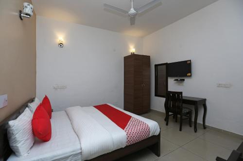 a bedroom with a bed and a desk and a television at OYO Mahak Residency in Gurgaon