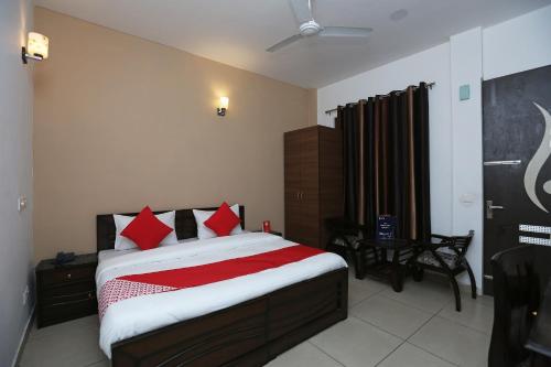 a bedroom with a large bed with red pillows at OYO Mahak Residency in Gurgaon