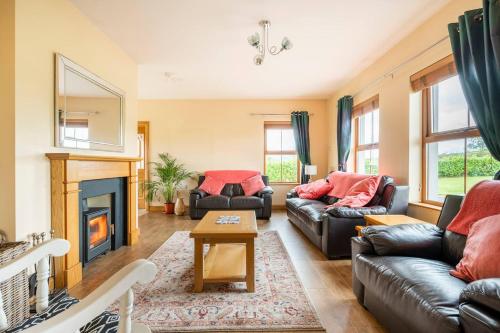 sala de estar con 2 sofás y chimenea en Bin Mountain Self Catering, en Castlederg
