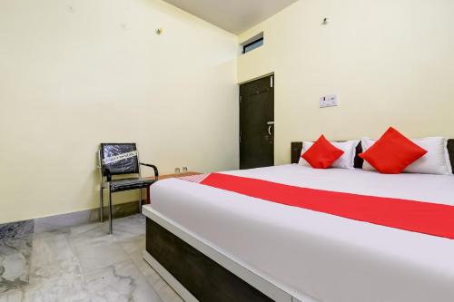 a bedroom with a large white bed with red pillows at Hotel Basera in Bankipur