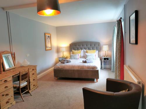 um quarto com uma cama, uma secretária e uma cadeira em Romantic Cottage with Private Hot Tub em Llanfyrnach
