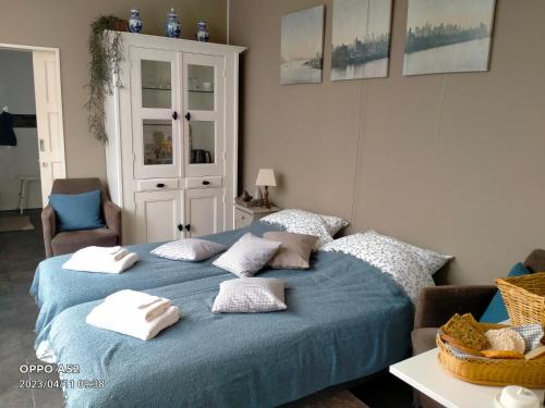 a bedroom with a blue bed with pillows on it at De Grindweg in Holten
