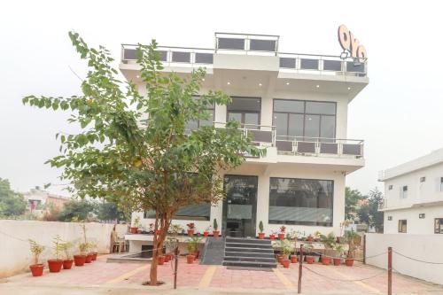 a building with a tree in front of it at Super OYO Taj Classic in Tājganj