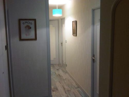 - un couloir avec une porte menant à une chambre dotée de parquet dans l'établissement Chambre Olivier, au Mans