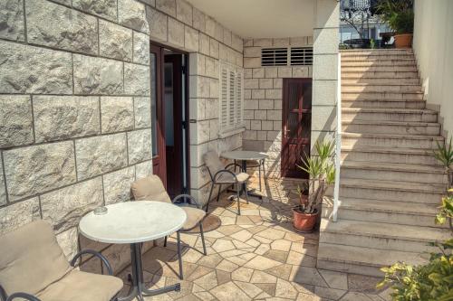 a patio with a table and chairs and stairs at Guesthouse Victoria II in Dubrovnik