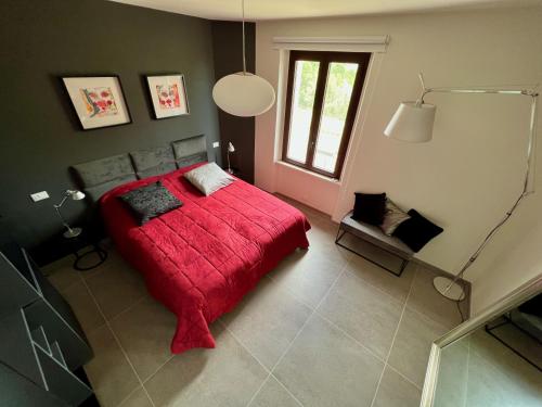 a bedroom with a red bed and a window at Agriturismo Colpo di Fortuna in Gualdo di Macerata