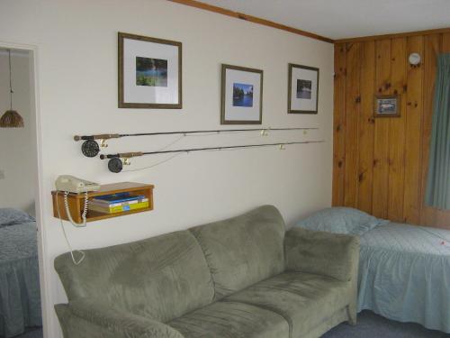 a living room with a couch and a bed at Tongariro River Motel in Turangi