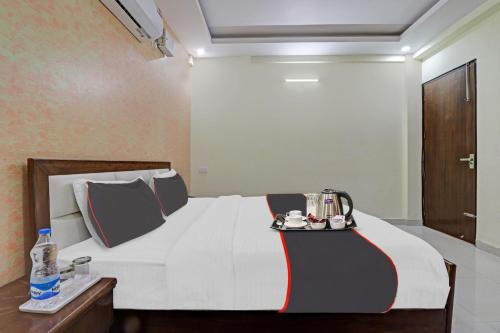 a bedroom with a bed with a tray of food on it at Collection O Hotel Premnagar Heights in Dehradun