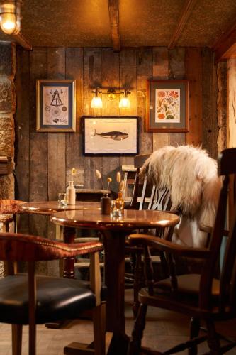 a dining room with a wooden table and chairs at Harbour Inn in Porthleven