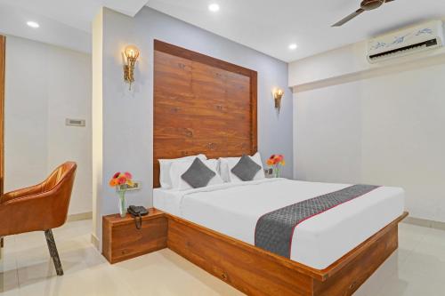 a bedroom with a large bed and a chair at Super Townhouse 1185 Rcc Pride in Hyderabad