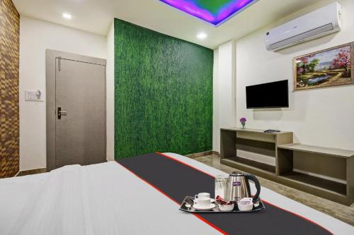 een hotelkamer met een bed en een televisie bij Super Collection O Hotel The Whistler in Bhopal