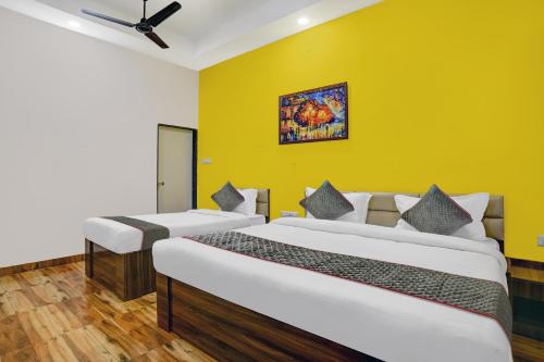 印多爾的住宿－Townhouse Hotel Pine Tree，黄色墙壁的客房内的两张床