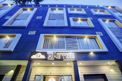 a blue building with a ping time sign on it at Townhouse Hotel Pine Tree in Indore