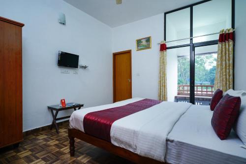 AnachalにあるOYO M S Holiday Resortのベッドルーム1室(ベッド1台、大きな窓付)