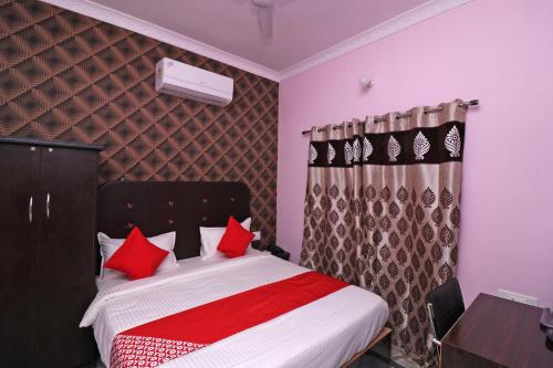 a bedroom with a bed with red pillows at Flagship Hotel Magadh Empire in Patna