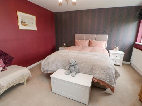 un osito de peluche sentado en una mesa en un dormitorio en Sea View Cottage, en South Shields
