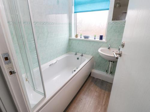 y baño con bañera y lavamanos. en Sea View Cottage en South Shields